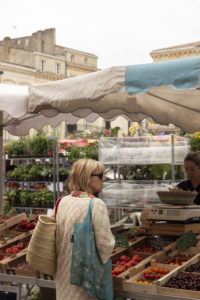 a lady buying vegetables at the libourne Sunday market